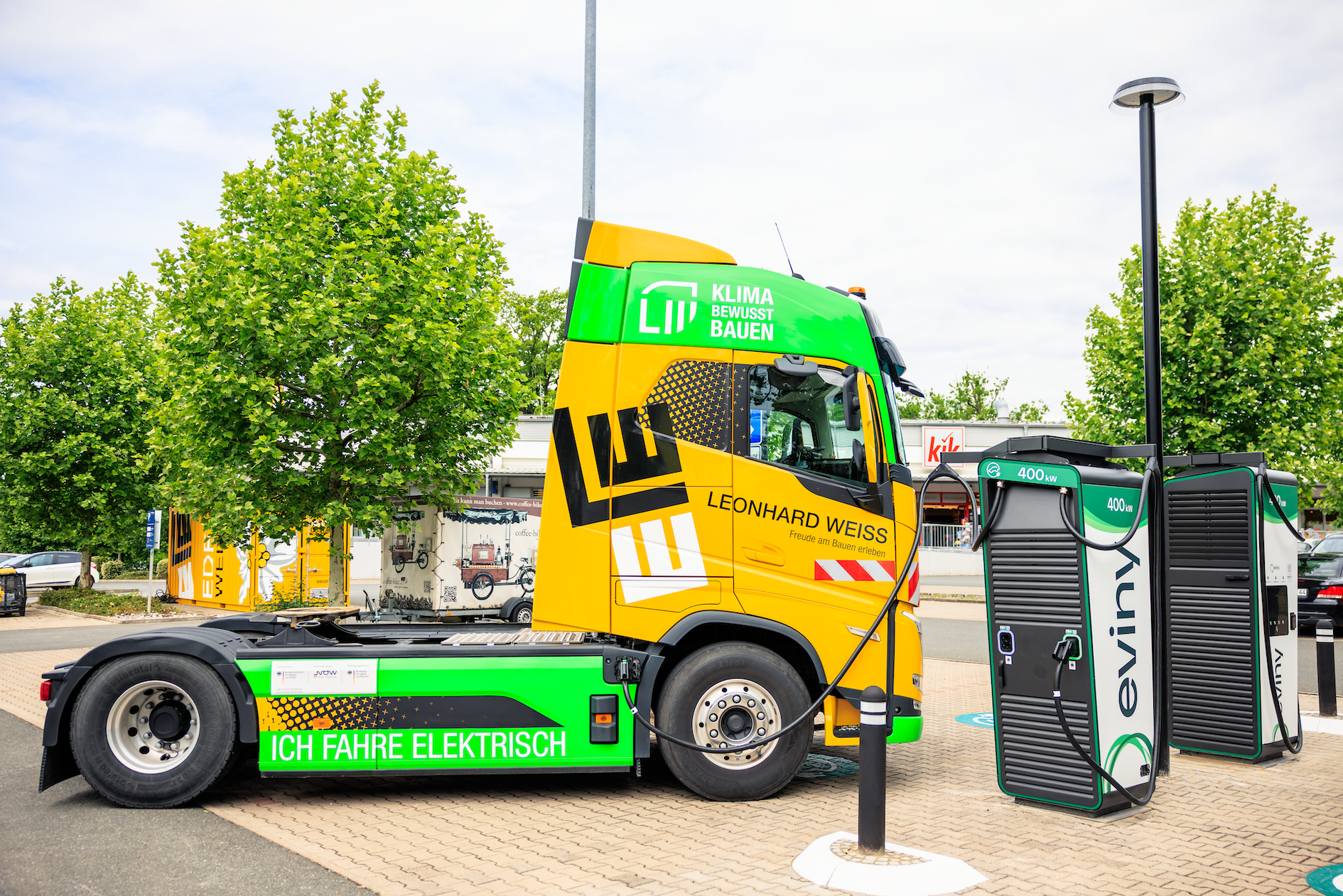 Ein gelber Elektro LKW wird am neuen Ladepark geladen.