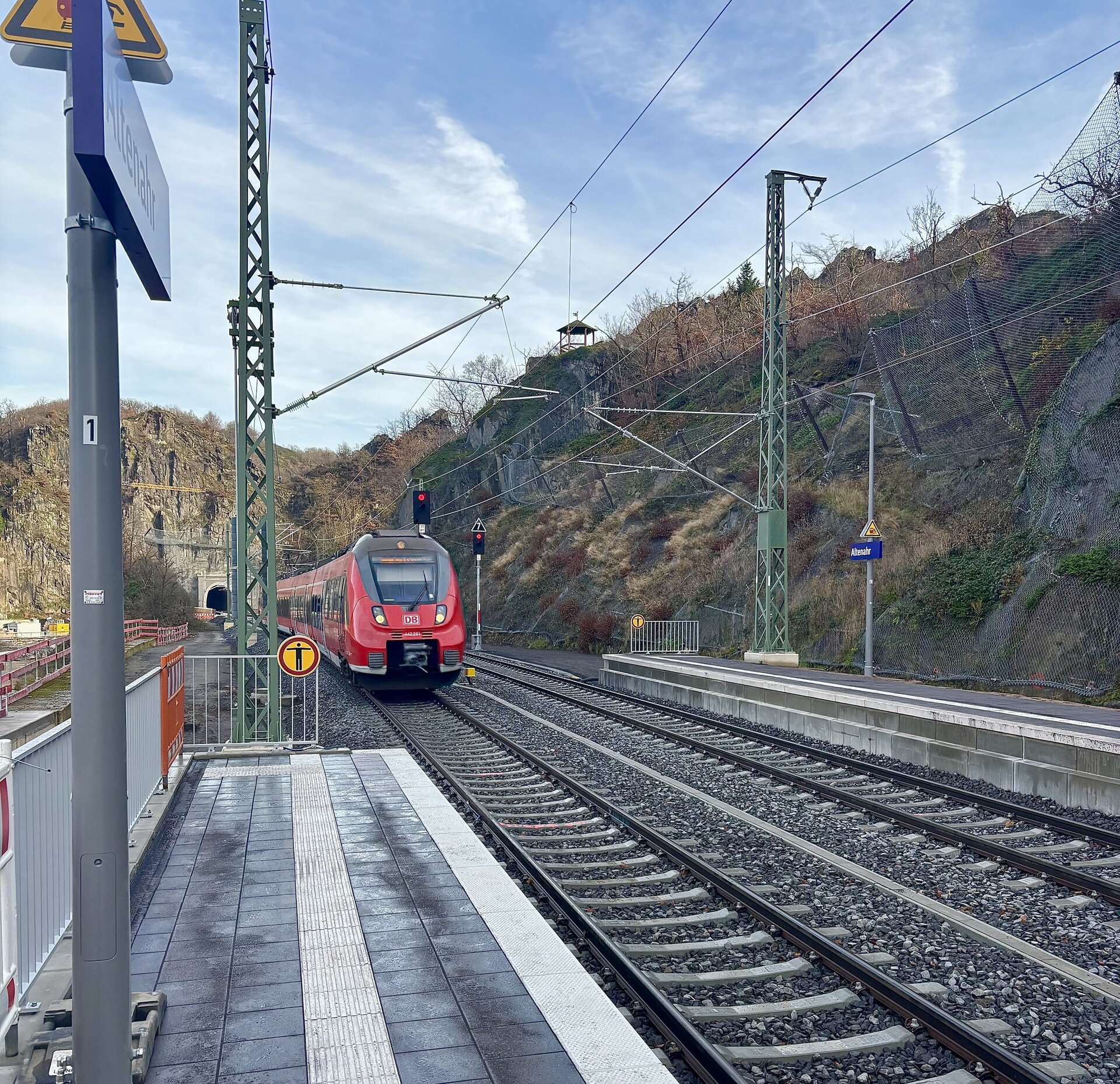 Ein Zug steht auf den Gleisen an einem Bahnhof.