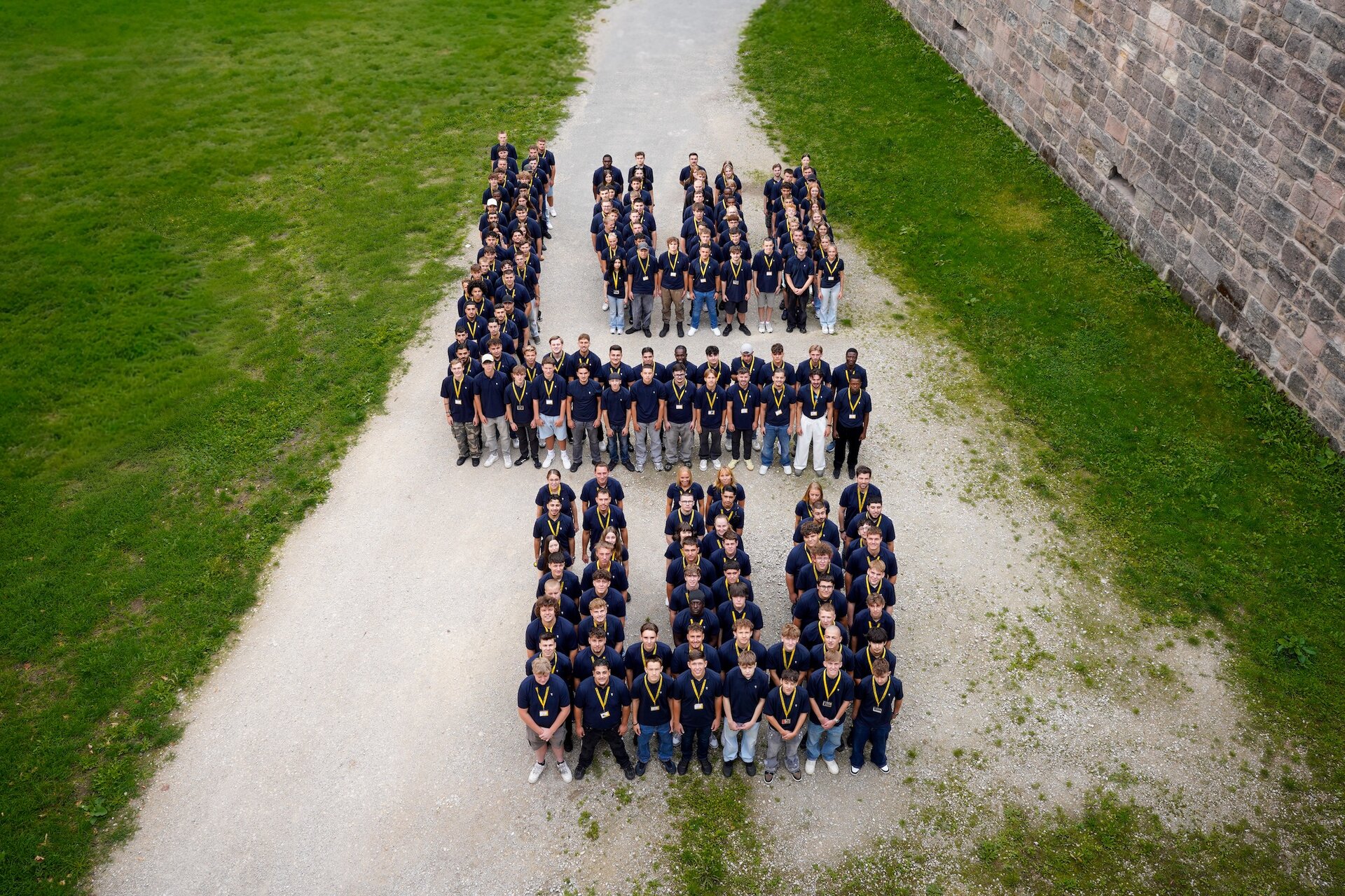 Eine Gruppe von Menschen steht vor einer Wand und posiert für ein Foto.