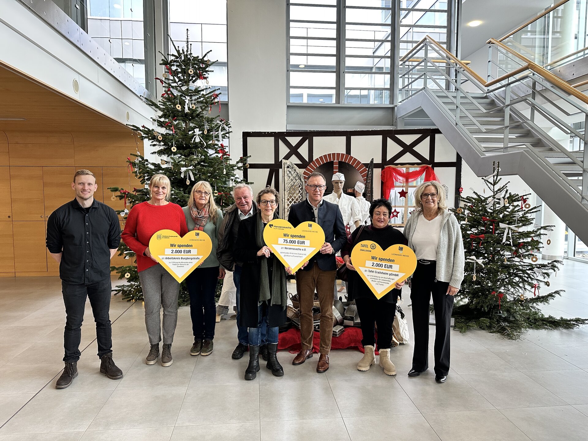 Eine Gruppe von Menschen hält herzförmige Schilder hoch und zeigt ihre Unterstützung und Freude.