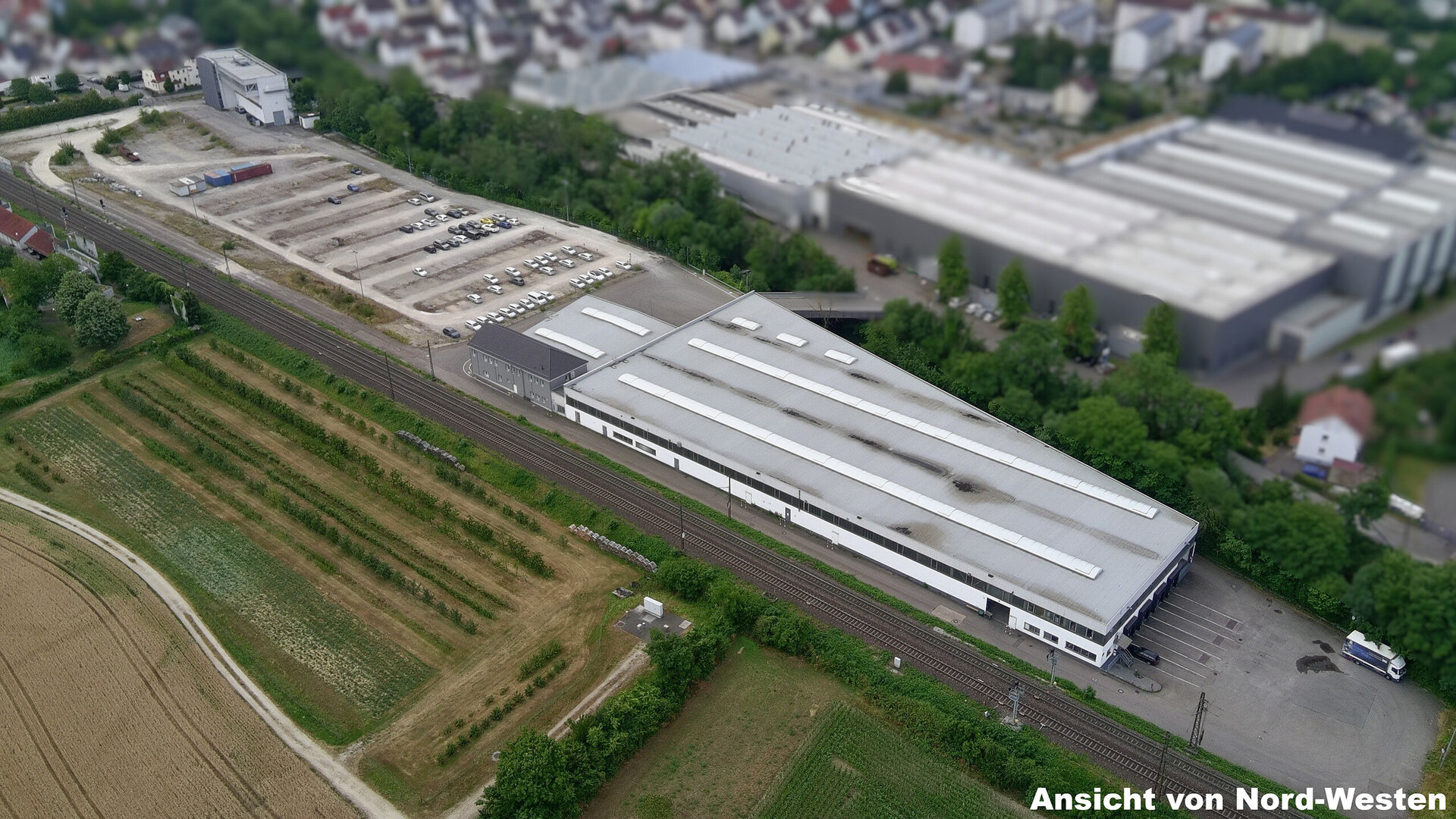 Eine weitläufige Ansicht eines Industriegebiets mit einem großen Lagergebäude und angrenzenden Parkplätzen.