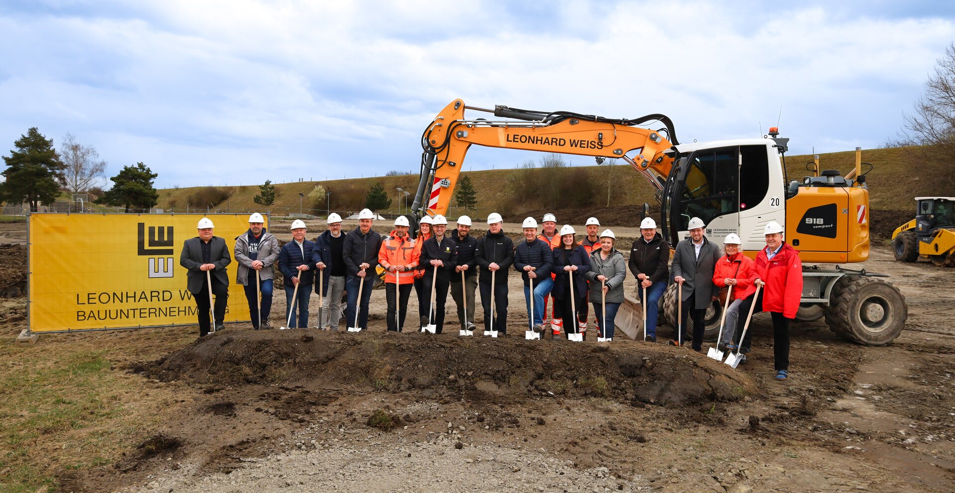 Menschen auf einer Baustelle bei einem Spatenstich.