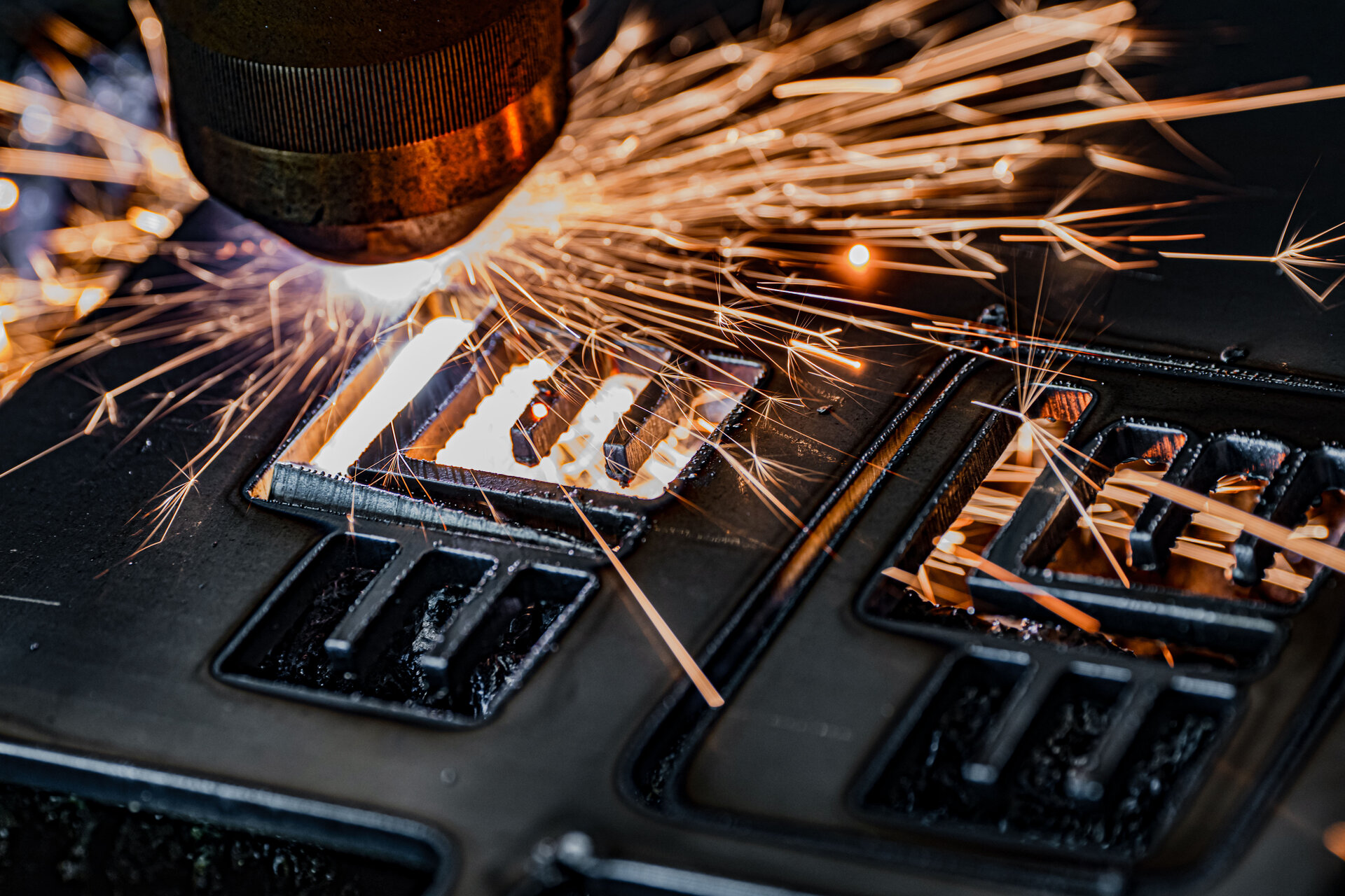 Ein präziser Laserstrahl schneidet durch Metall, während Funken in alle Richtungen sprühen und eine dynamische Szene erzeugen.
