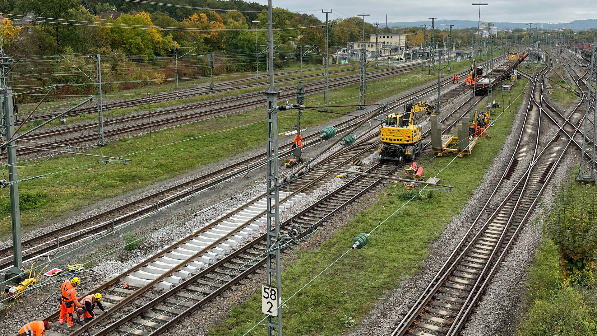 Arbeiter in orangefarbener Kleidung führen Gleisarbeiten auf dem Bahnhofsgelände von Bad Friedrichshall-Jagstfeld durch.