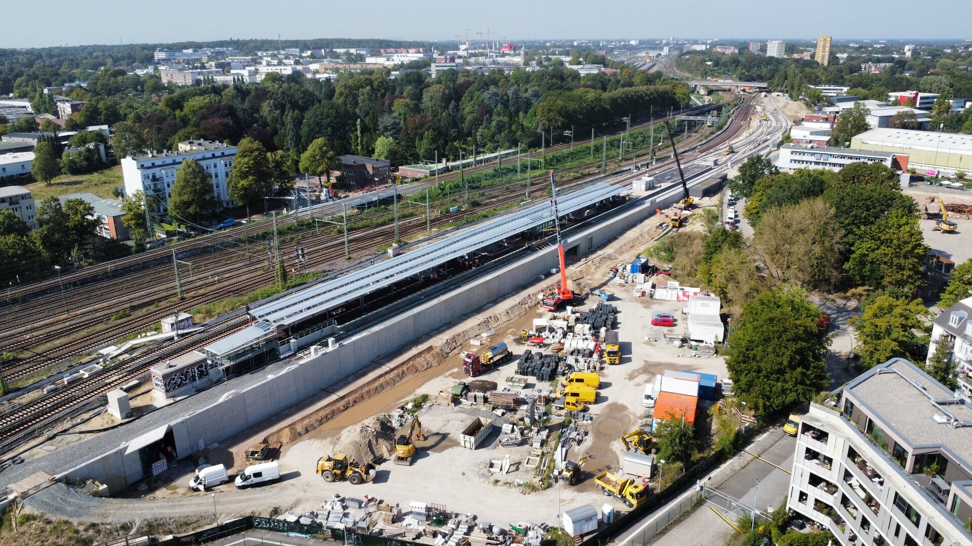 Luftansicht des Bahnsteig 1 des Bahnhofs Diebsteich beim Einbau des Asphaltbelages und Autokräne zum Vertikaltransport des Asphaltes